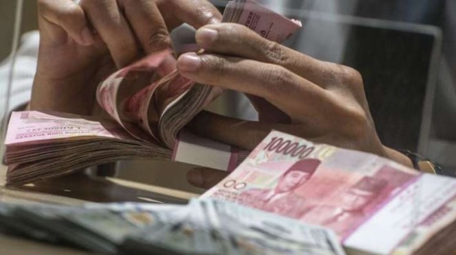Menghitung uang kertas rupiah pecahan 100 ribu (Foto ilustrasi)
